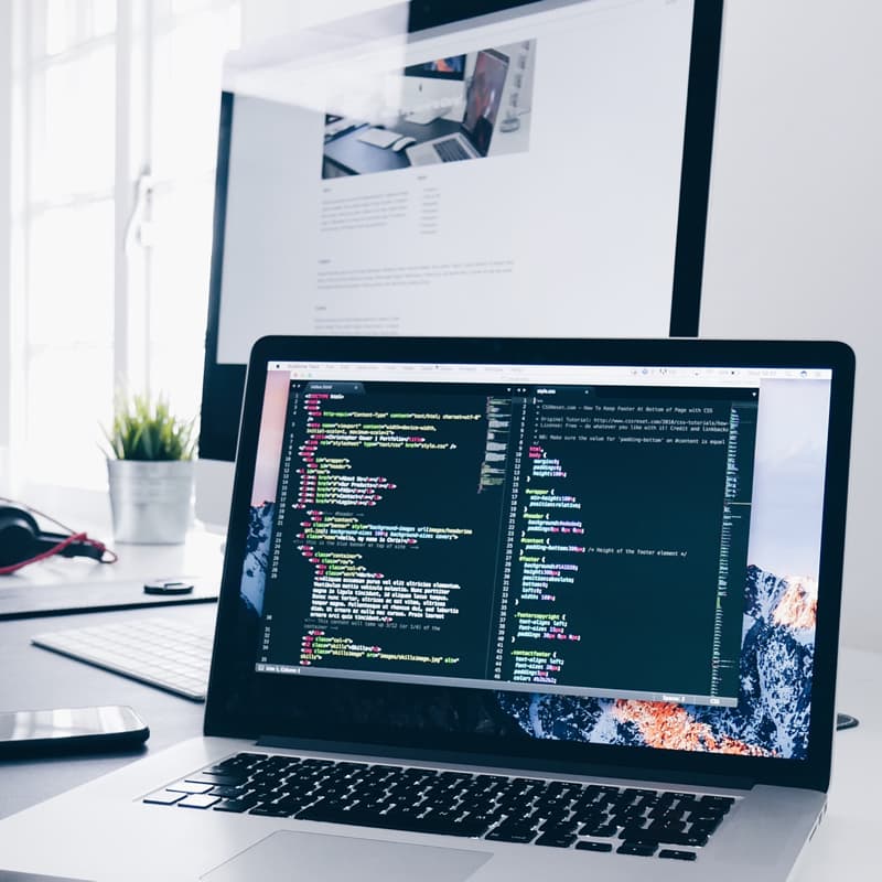 Laptop & macbook displaying images of web design code and web design